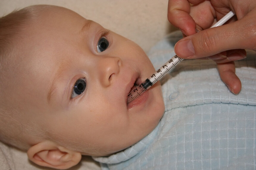 Малышу дают лекарство с помощью шприца