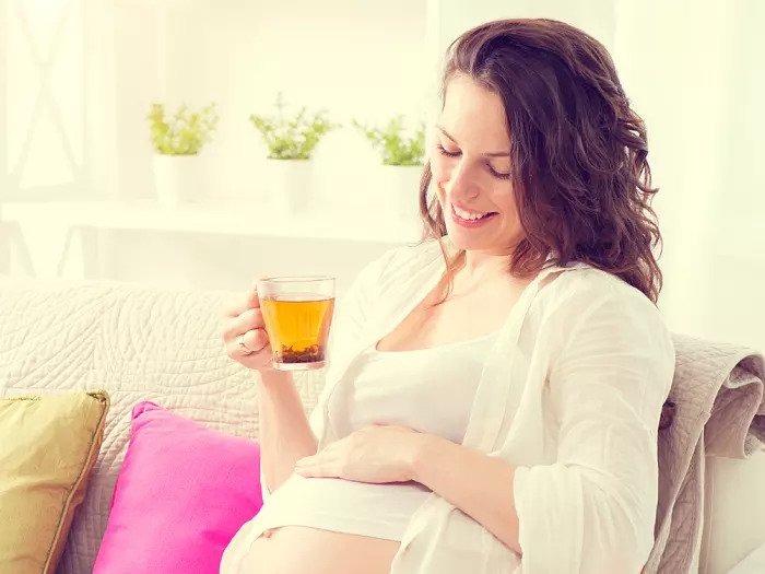 Беременная женщина пьет чашку чая
