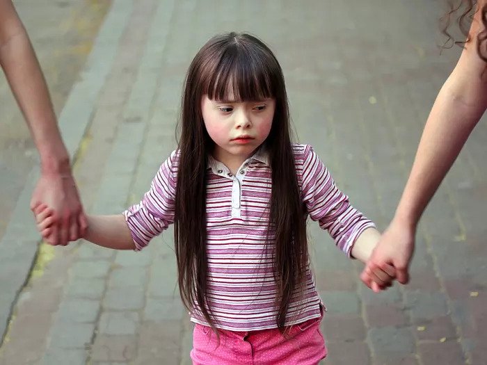 Грустная девушка держит ее сестры руки