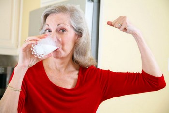 Пожилая женщина пьет молоко
