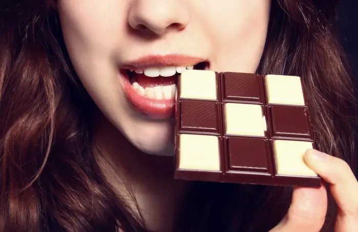 Женщина ест шоколад