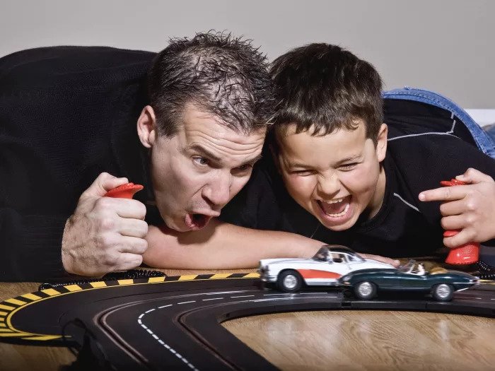Отец и сын играют в электромобили