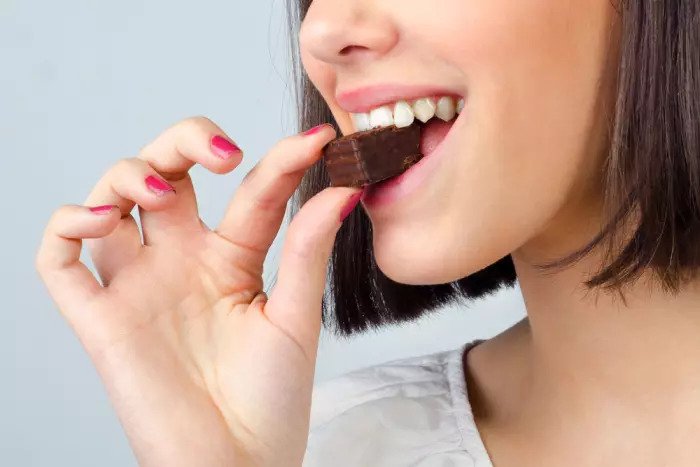 Женщина ест шоколад