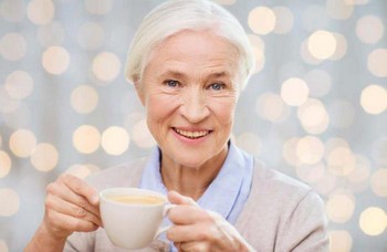 Пожилая женщина пьет чай