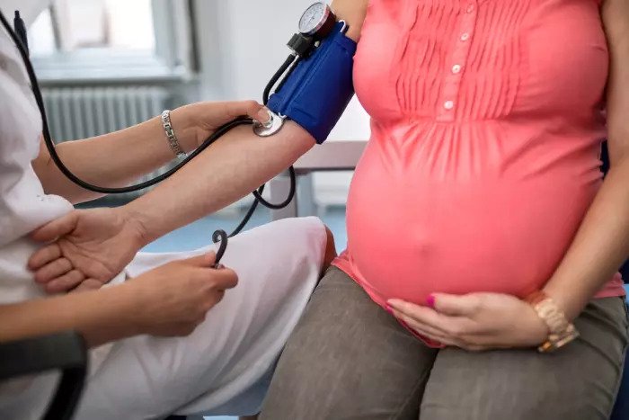 Беременная женщина измеряет артериальное давление